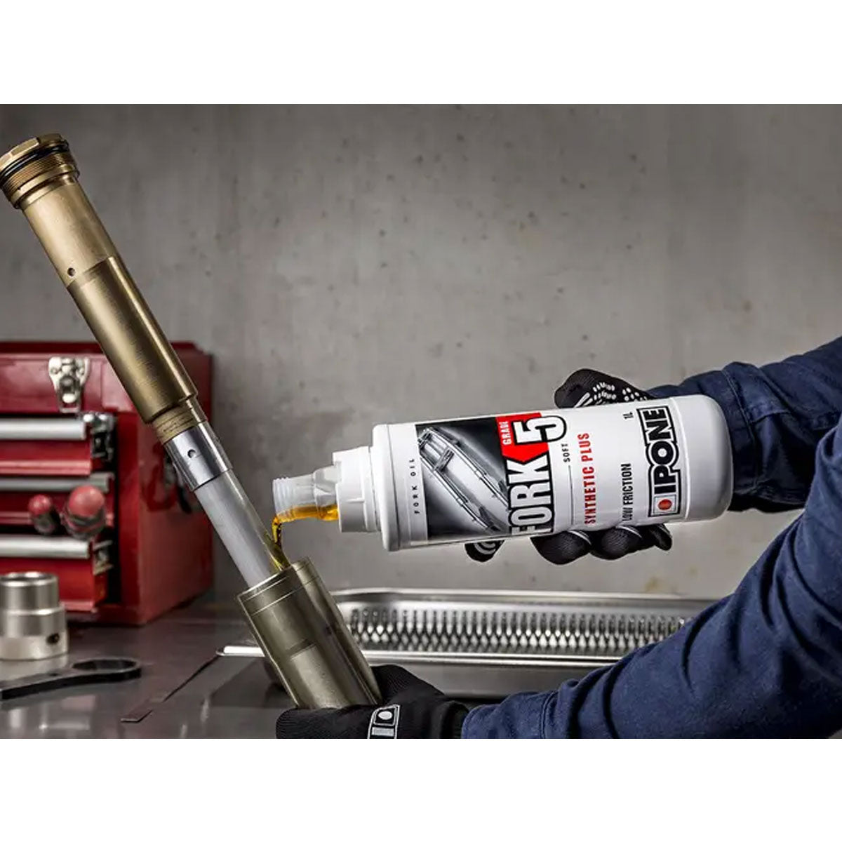 IPONE Semi-Synthetic Plus Fork Oil 5W in use, being poured.