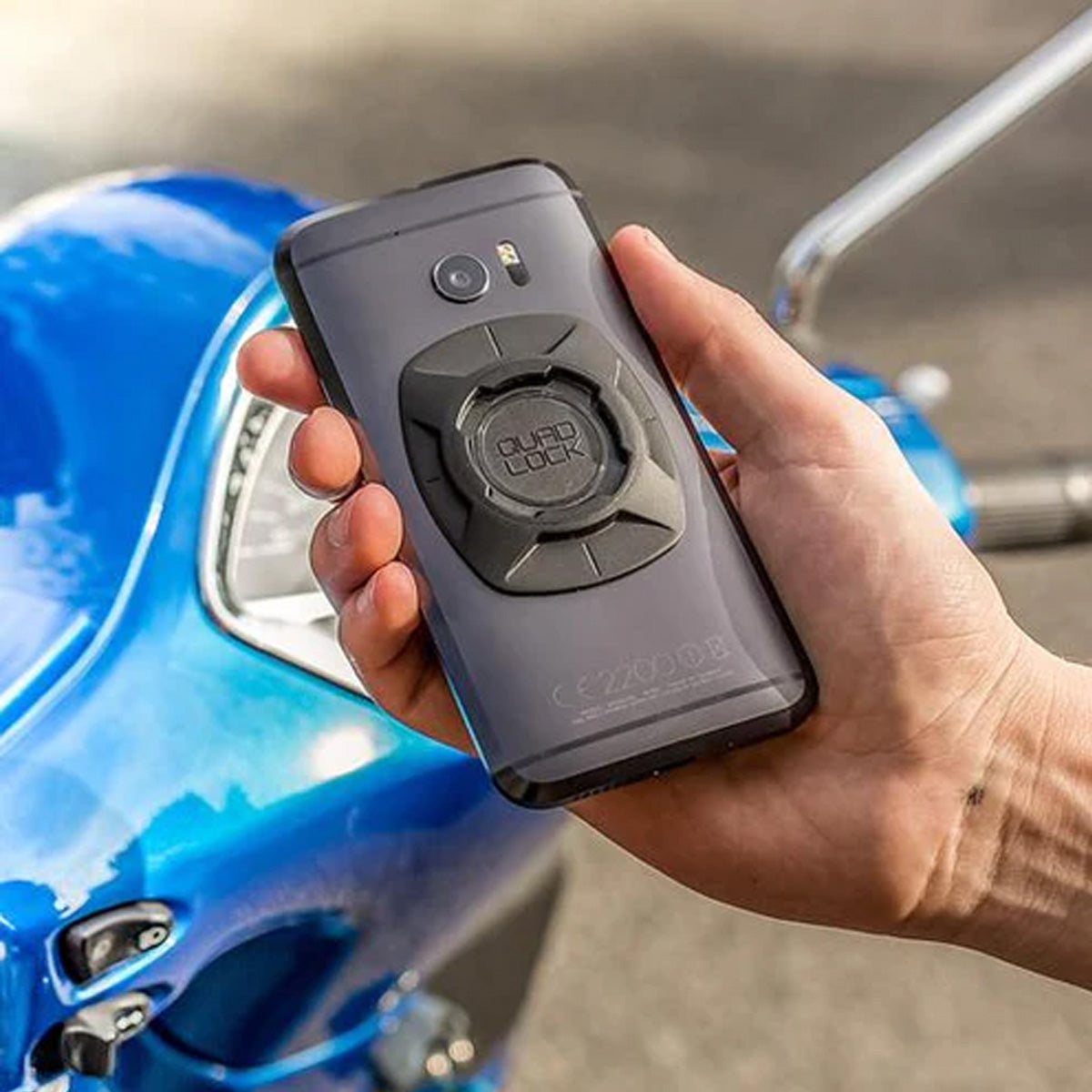 The Quad Lock Universal Adaptor about to be used on a motorycle handlebar