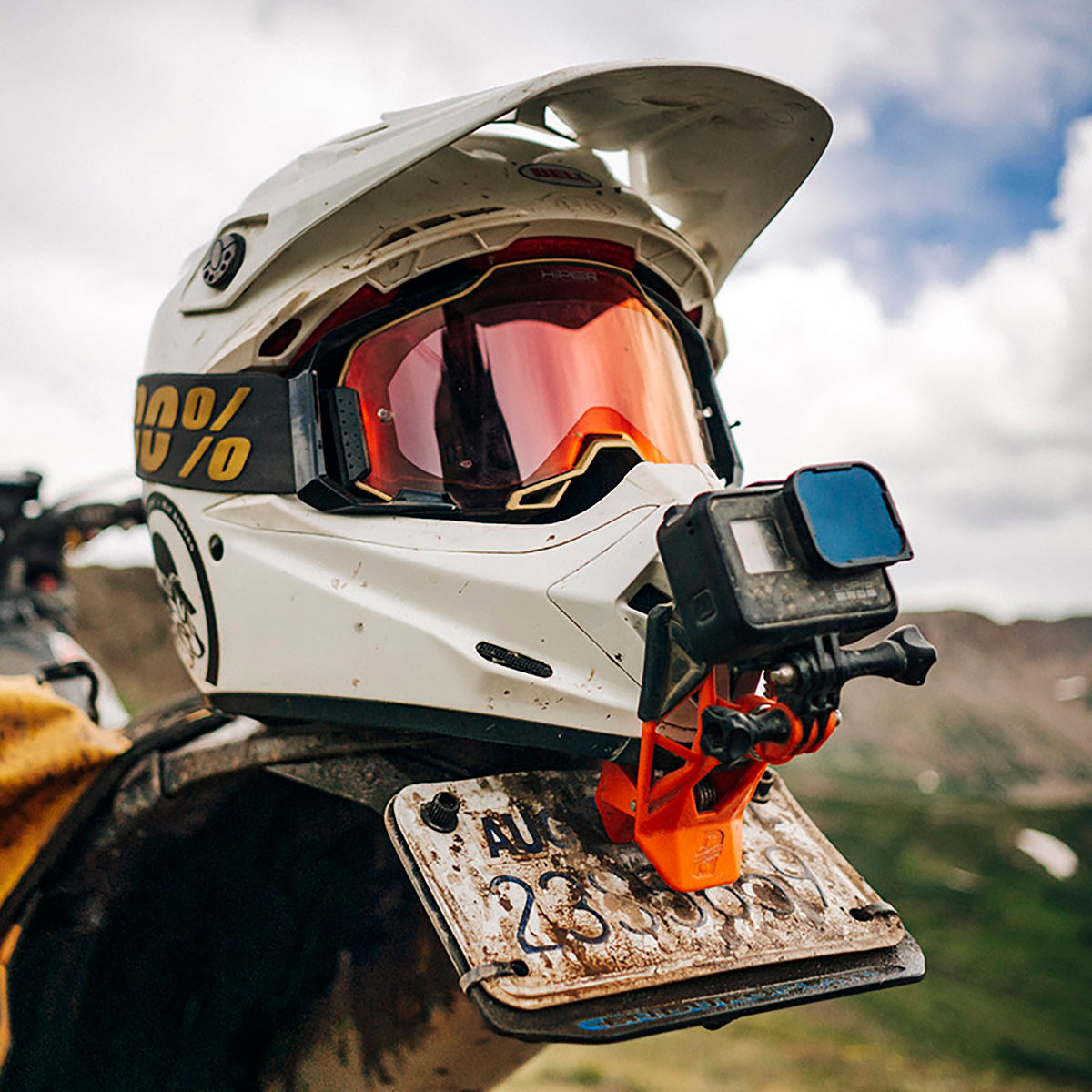 Orange Gripper GoPro Helmet Mount fitted to a white helmet resting on rear bike fender
